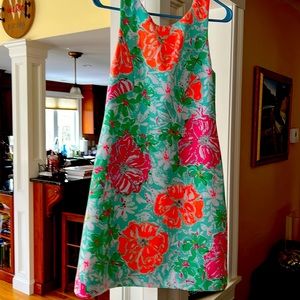 A line shift dress with gold zipper down the back.Vibrant colors and pattern.